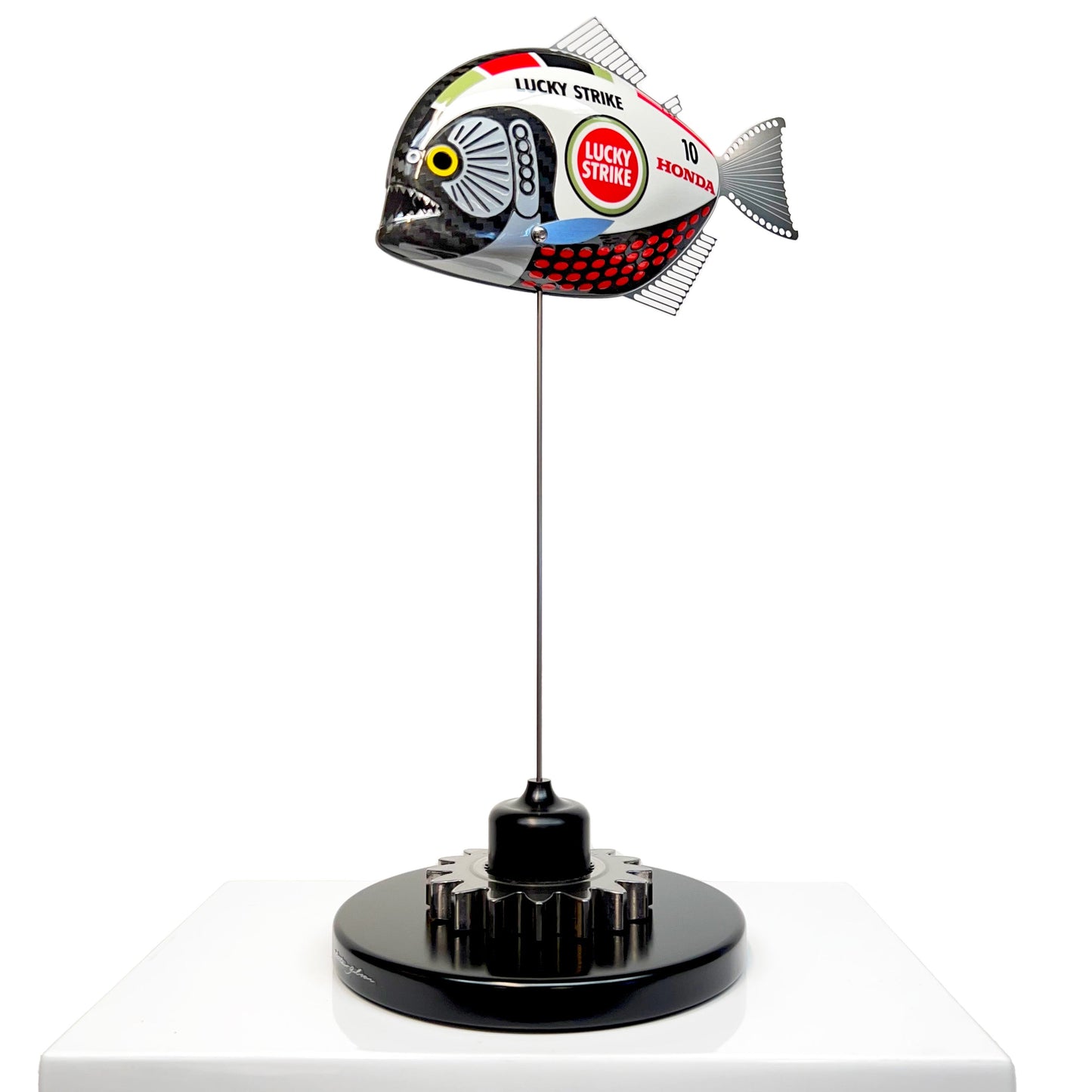 Carbon fibre baby piranha sculpture with BAR Honda F1 livery on a black base with F1 gear