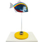 Carbon fibre piranha fish sculpture with NHS rainbow livery on a sandy base with F1 part