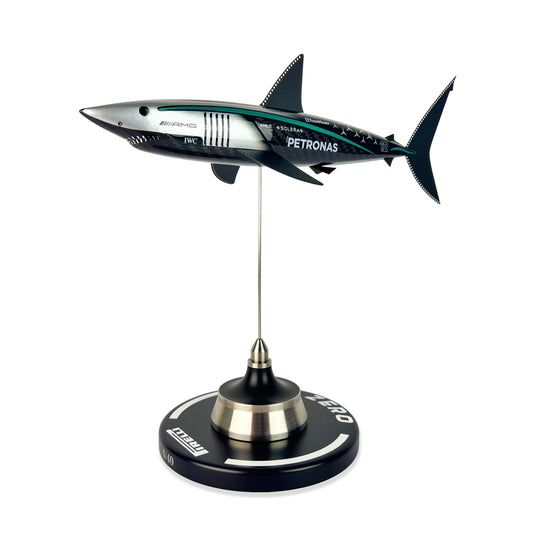 Carbon Fibre Sculpture of a shark with Mercedes racing livery on a stand against a white background