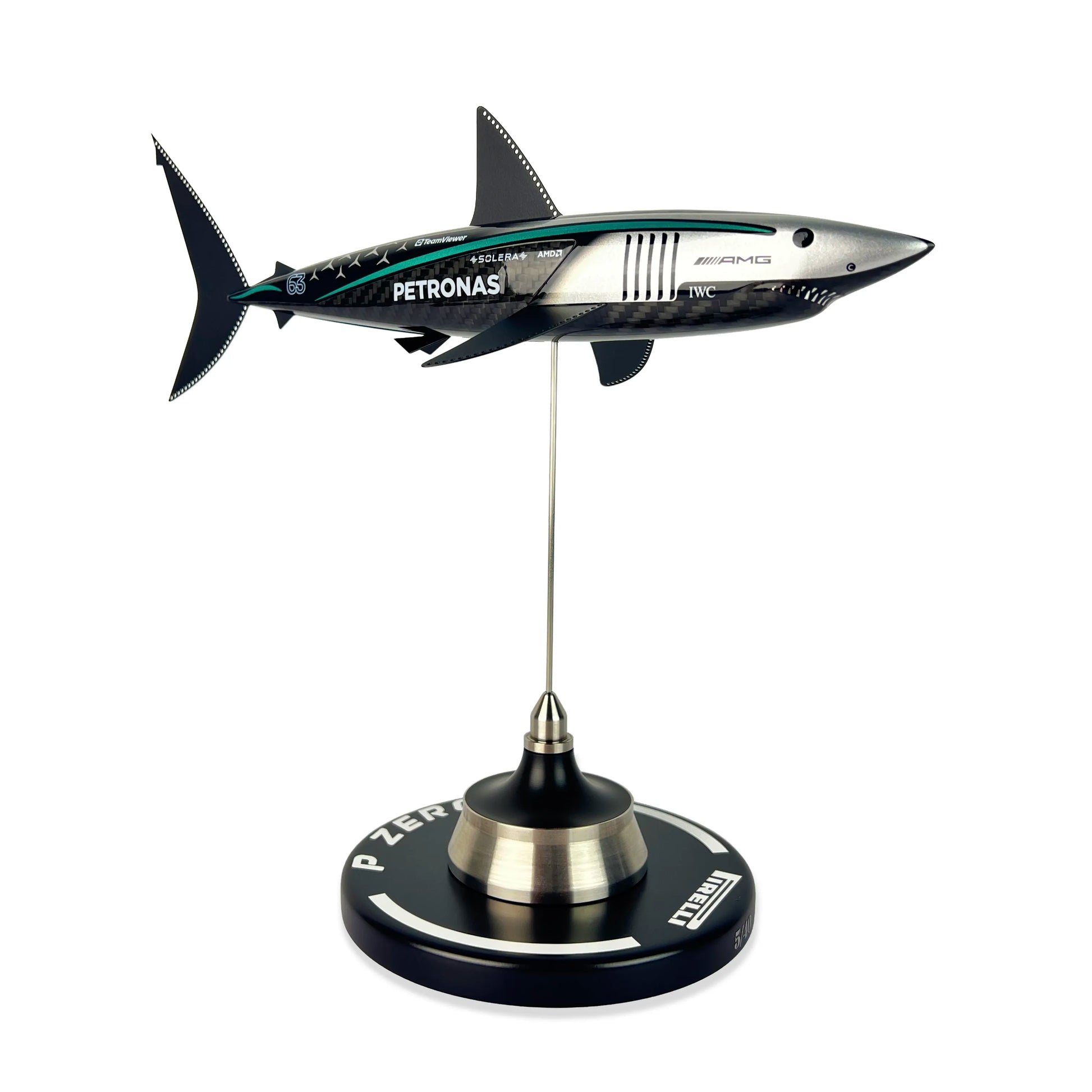 Carbon Fibre Sculpture of a shark with Mercedes racing livery on a stand against a white background