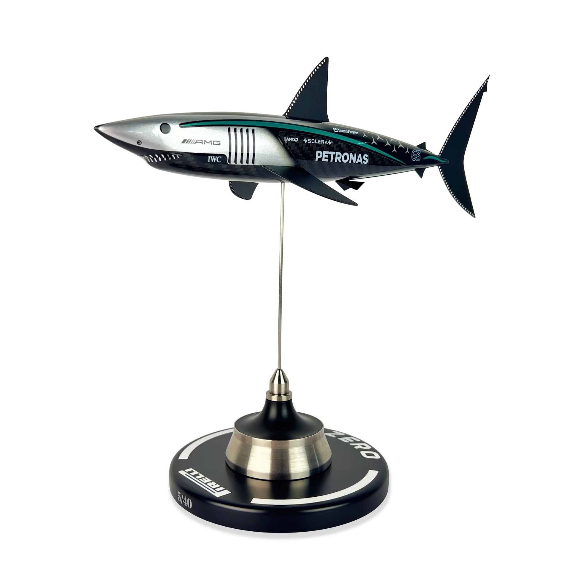 Carbon Fibre Sculpture of a shark with Mercedes racing livery on a stand against a white background