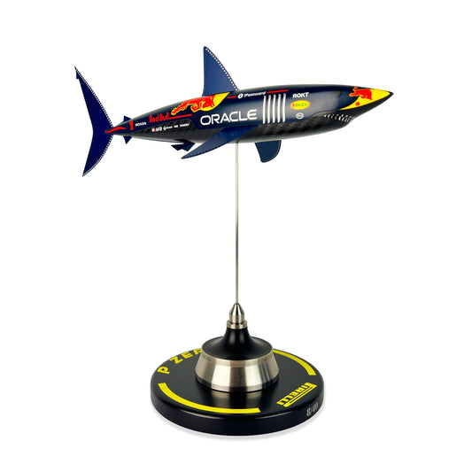 Carbon Fibre Sculpture of a shark with RedBull racing livery on a stand against a white background