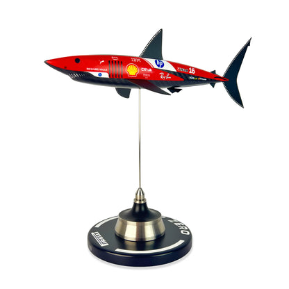 Carbon Fibre Sculpture of a shark with Ferrari Inspired racing livery on a stand against a white background