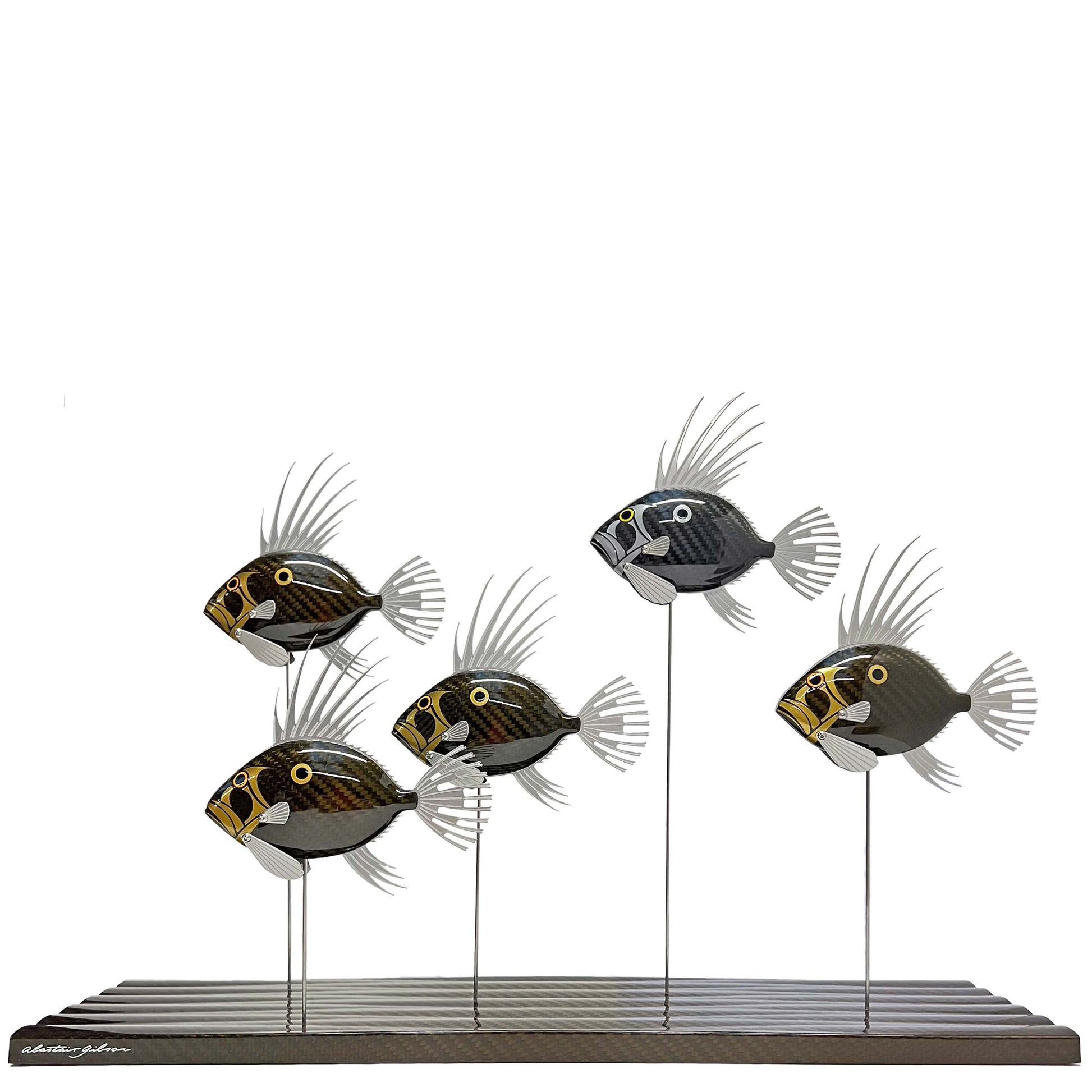 Carbon fibre school of gold and silver John Dory fish on a gold carbon fibre wave base