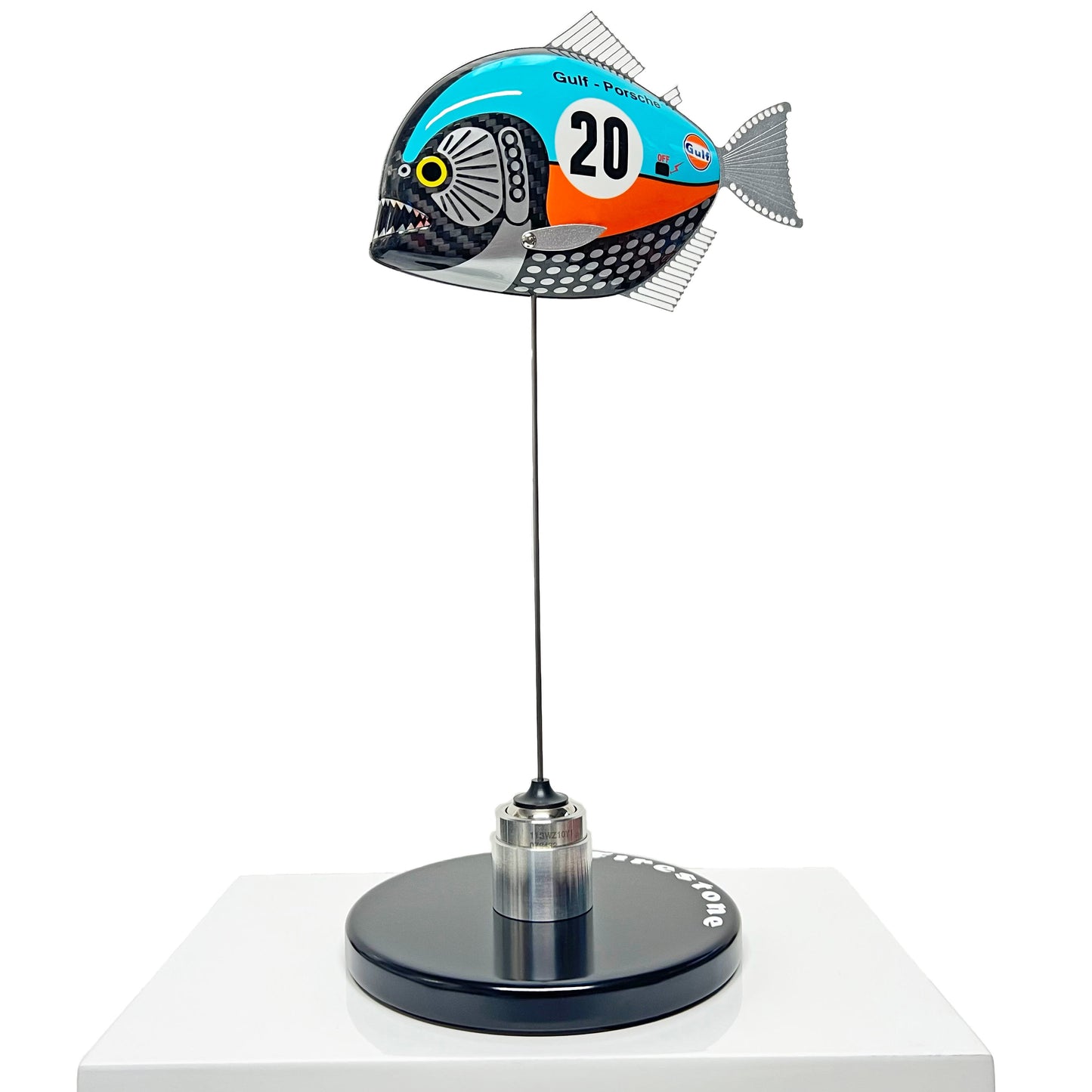 Carbon fibre piranha sculpture with Gulf Porsche Livery on a black base with F1 parts