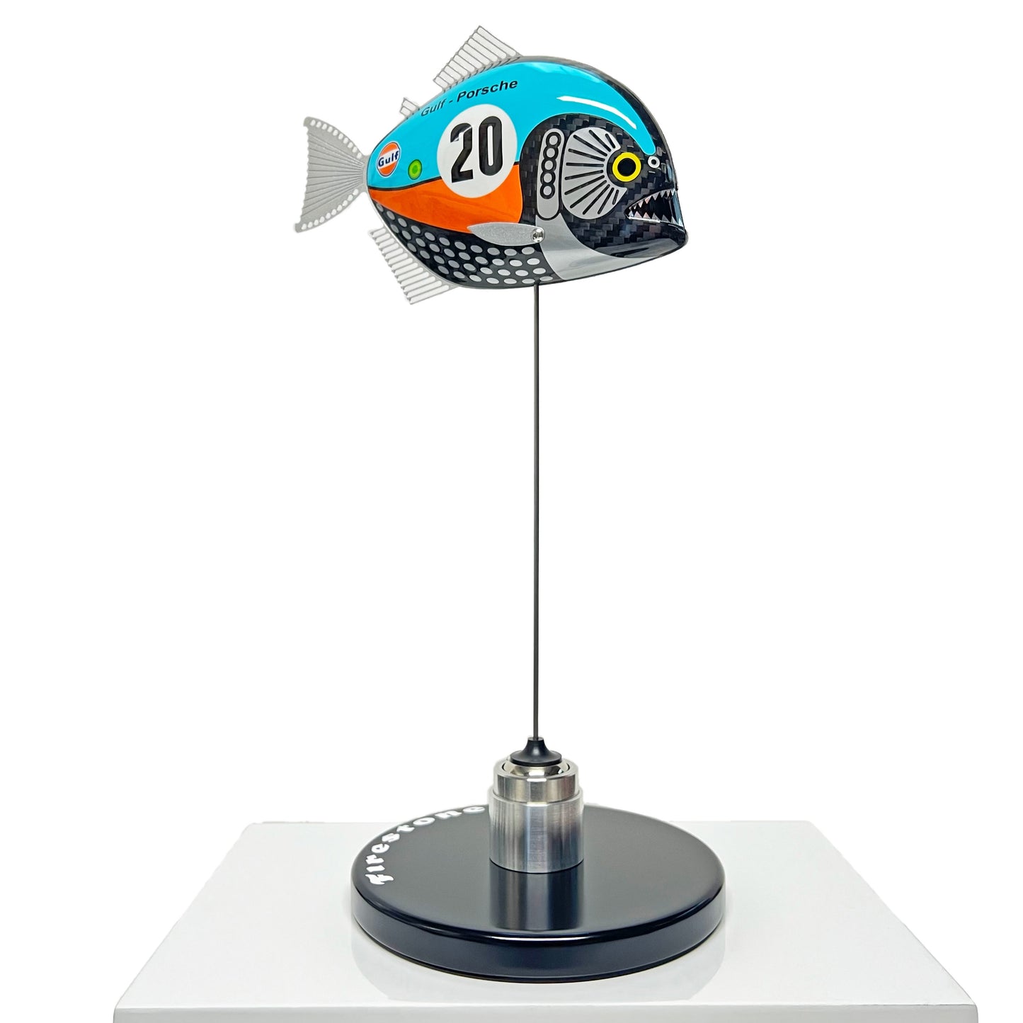 Carbon fibre piranha sculpture with Gulf Porsche Livery on a black base with F1 parts