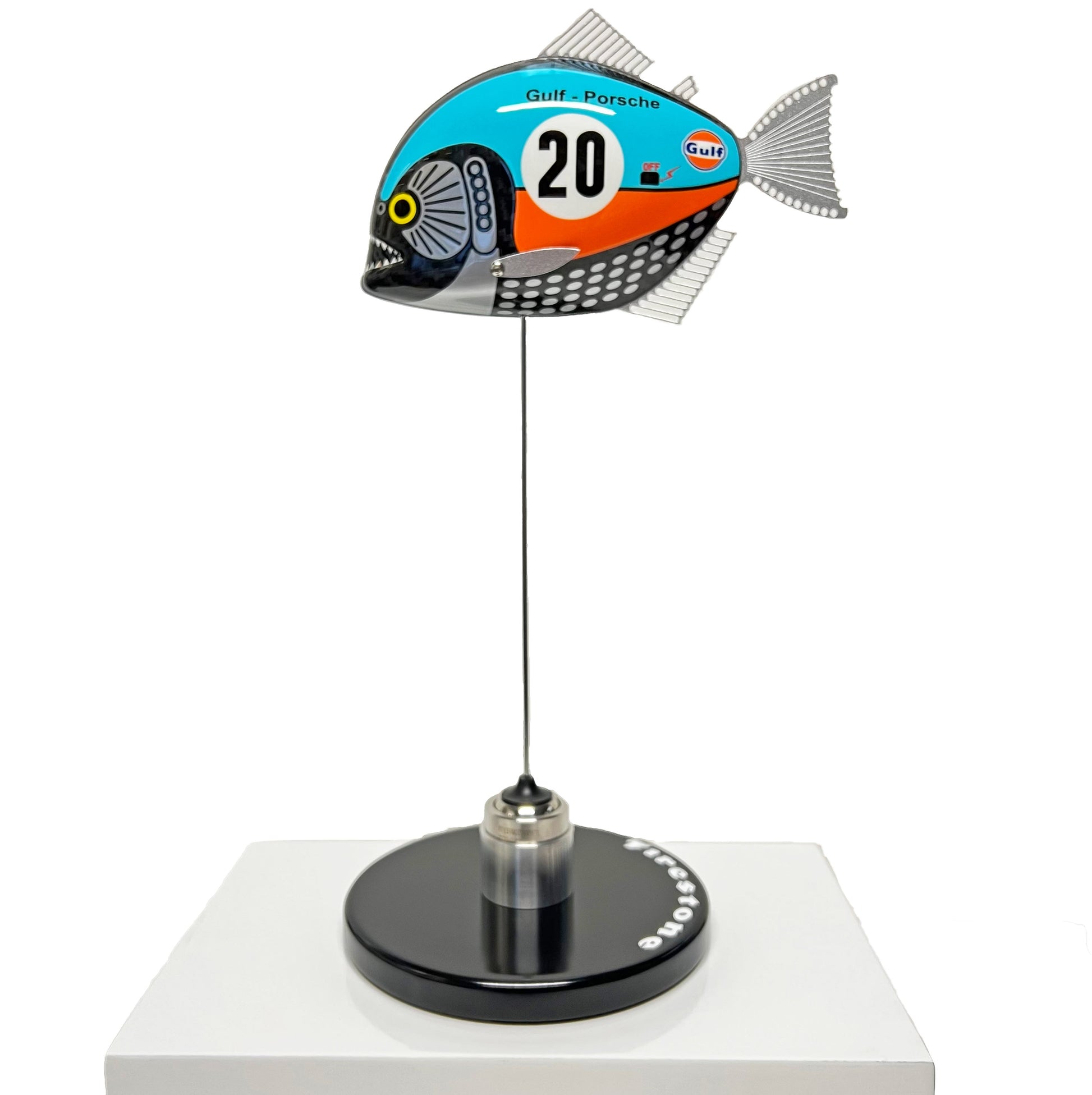 Carbon fibre piranha sculpture with Gulf Porsche Livery on a black base with F1 parts
