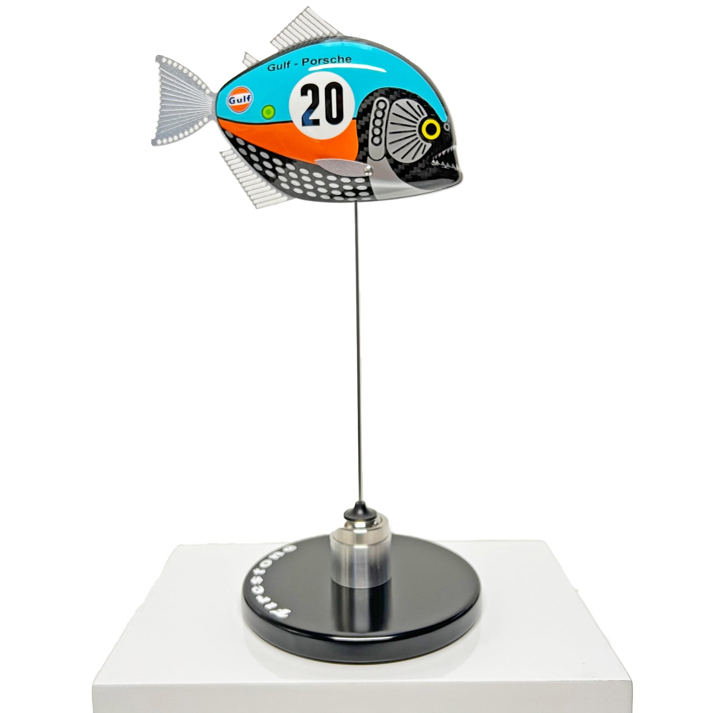 Carbon fibre piranha sculpture with Gulf Porsche Livery on a black base with F1 parts