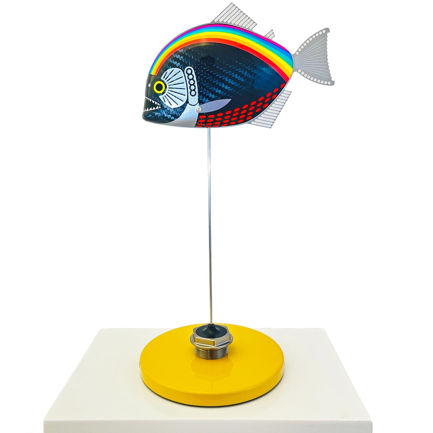 Carbon fibre piranha fish sculpture with NHS rainbow livery on a sandy base with F1 part